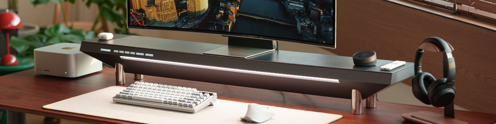Modern office desk setup with computer monitor, keyboard, mouse, and headphones.