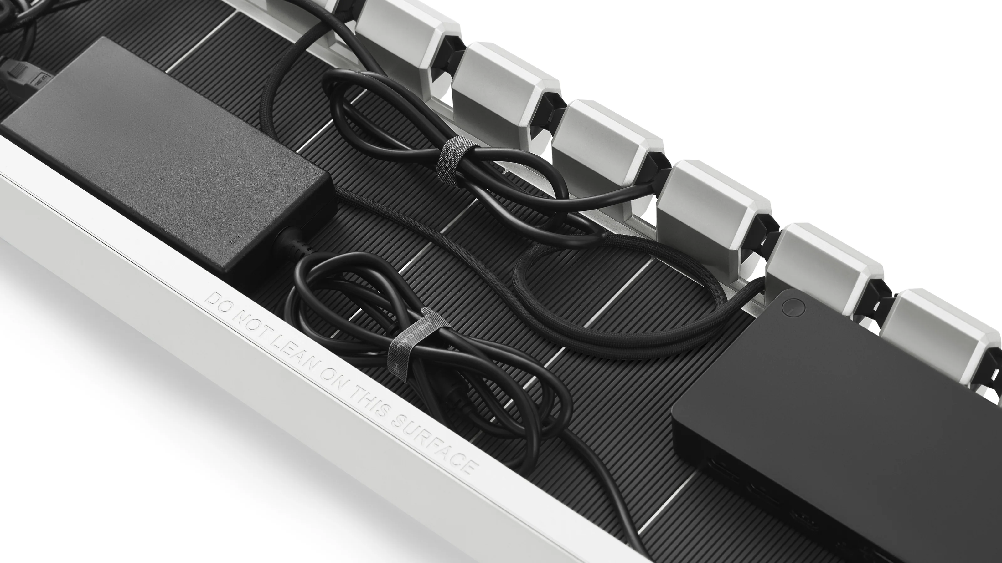 Top view of Hexcal Studio cable management tray with organized power adapters and neatly coiled cables.